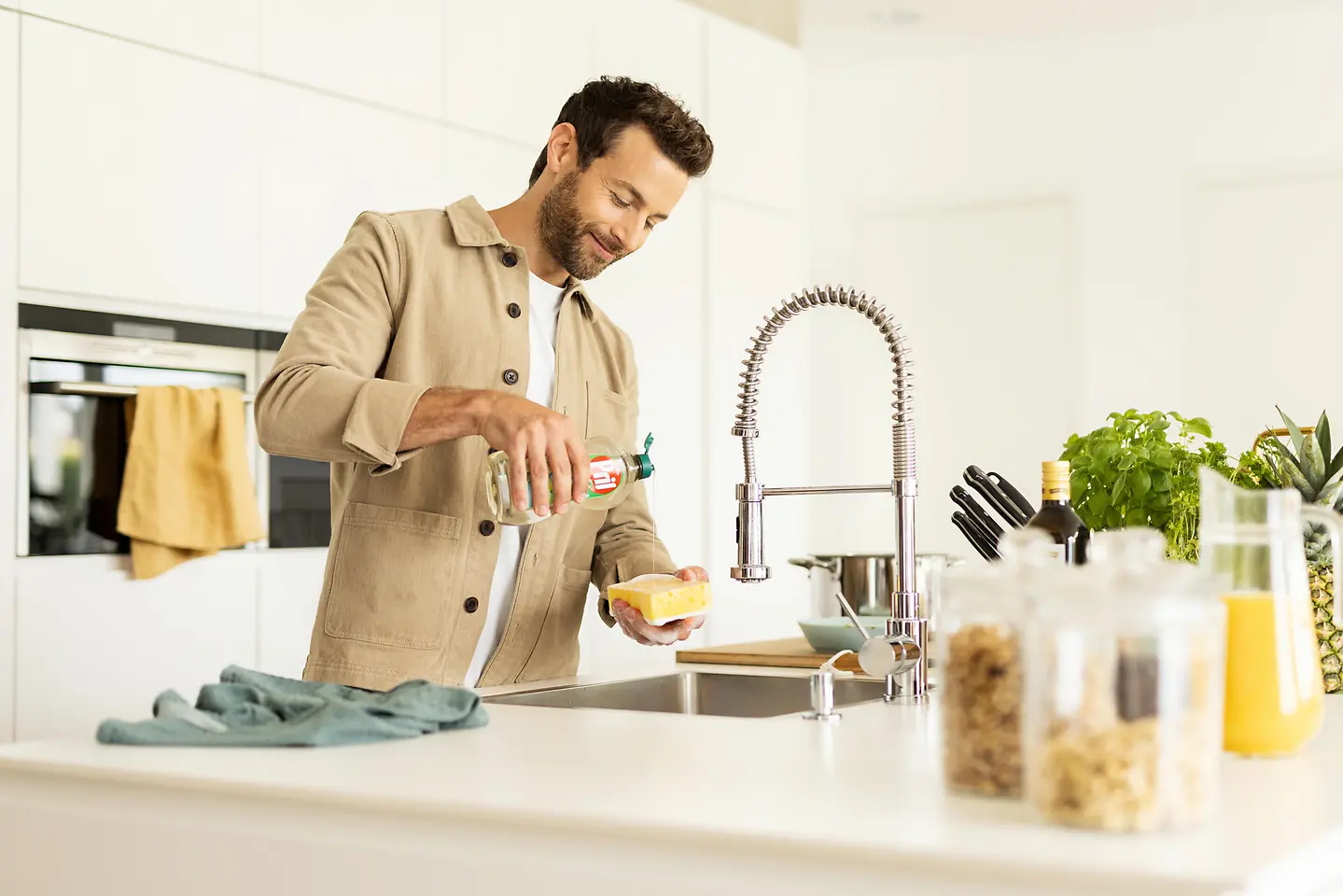 رجل في المطبخ يقوم بغسل الأطباق