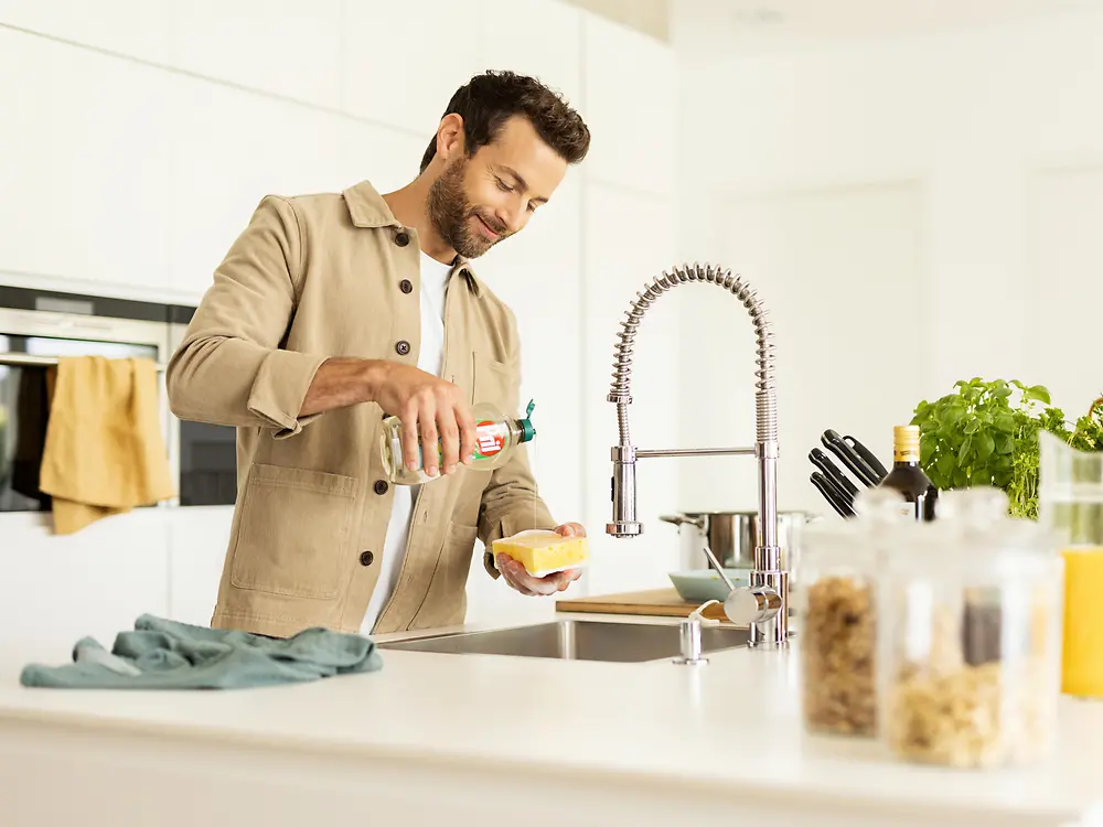 رجل في المطبخ يقوم بغسل الأطباق